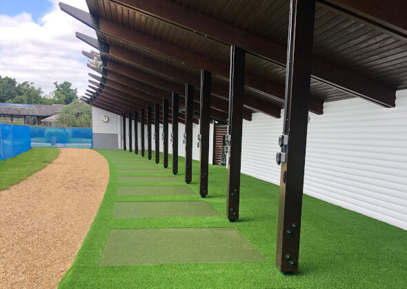 Atlanta Covered outdoor tee line with light green synthetic grass boxes inside a dark green synthetic grass strip